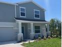 Inviting two-story home showcases a covered porch with stone accents and fresh landscaping at 2005 Canton Park Dr, Winter Haven, FL 33881