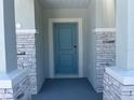 Stylish blue front door framed by stone pillars, offering a welcoming entrance at 2005 Canton Park Dr, Winter Haven, FL 33881