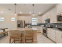 Bright kitchen boasts stainless steel appliances, grey backsplash, pendant lighting, and an island with seating at 2721 Serenity Meadow Dr, Kissimmee, FL 34744