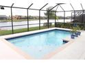 Sparkling pool enclosed by a screen with a scenic lake backdrop at 3039 Boating Blvd. Blvd, Kissimmee, FL 34746