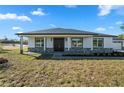 Well-manicured single-story home featuring stone accents and a stylish double-door entrance at 31905 Larkspur Ave, Eustis, FL 32736