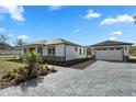 Beautiful single-story home with a paved driveway leading to a detached garage at 31905 Larkspur Ave, Eustis, FL 32736
