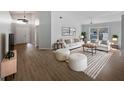 Bright living room with vaulted ceiling, wood flooring, neutral color palette, and ample natural light at 332 Lake Doe Blvd, Apopka, FL 32703