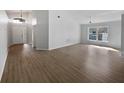 Spacious living room with vaulted ceiling, wood flooring, and large window at 332 Lake Doe Blvd, Apopka, FL 32703
