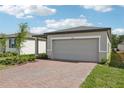 Exterior view of a one-story home with a two-car garage and landscaped front yard at 3876 Giorgio Dr, Winter Haven, FL 33884