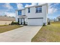 Inviting two-story home with a long driveway, attached garage, and manicured front yard at 39 Hickory Course Way, Ocala, FL 34472