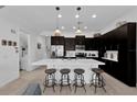 Modern kitchen with dark cabinets, white countertops, and stainless steel appliances at 394 Captiva Dr, Davenport, FL 33896