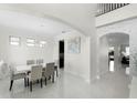 Bright dining room featuring modern chandelier, white tile floor, and views into the home at 612 Via Isabelle Dr, Debary, FL 32713