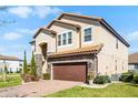 Charming two-story house with a terra cotta roof, stone accents, lush lawn, and a two-car garage at 612 Via Isabelle Dr, Debary, FL 32713