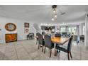Open concept dining room with neutral tile flooring and modern décor adjacent to the Gathering room at 638 Ogelthorpe Dr, Davenport, FL 33897