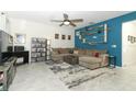 Comfortable living room featuring a large sectional sofa, area rug, and custom shelving on a teal accent wall at 701 Bonsai St, Apopka, FL 32703