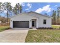 A modern one-story home with a gray garage door and well-maintained lawn at 7117 Sw 131St Ave, Ocala, FL 34481