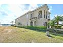 Spacious home with a manicured lawn, mature landscaping, and a side view of the house and three-car garage at 7824 Loxahatchee Ct, Reunion, FL 34747