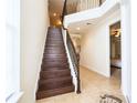 Elegant staircase with wooden steps, decorative iron railing, and neutral walls leading to the upper level at 7824 Loxahatchee Ct, Reunion, FL 34747