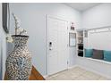 Inviting entryway featuring a coat rack bench, decorative vase, and neutral color palette at 926 Paradise Dr, Davenport, FL 33897