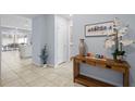 Bright hallway with tile flooring leading to kitchen and a decorative console table at 926 Paradise Dr, Davenport, FL 33897