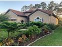 Inviting home featuring a well-kept lawn and diverse landscaping with vibrant plants and trees at 9346 San Jose Blvd, Howey In The Hills, FL 34737