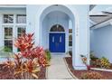 Inviting front entrance features a blue double door, arched entryway and manicured garden at 1232 Scandia Ter, Oviedo, FL 32765