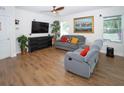 Comfortable living room featuring wood-look tile floors, a ceiling fan, and neutral paint at 1588 Diamond Loop Dr, Kissimmee, FL 34744