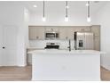 Modern kitchen featuring stainless steel appliances, pendant lighting, and a center island with a sink at 1959 Keel Ct, The Villages, FL 34762