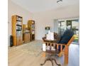 Bright living room showcases wood flooring, a comfortable sitting area, and a large window with a backyard view at 1959 Keel Ct, The Villages, FL 34762