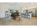Open-concept living area boasts wood flooring, lots of light, and a convenient breakfast bar overlooking the kitchen at 1959 Keel Ct, The Villages, FL 34762