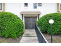 Close-up of a condo entrance featuring double doors, a walkway, and manicured bushes at 200 Maitland Ave # 86, Altamonte Springs, FL 32701
