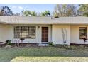 Inviting front entrance featuring a dark wooden door and manicured garden at 20240 Sw 95Th St, Dunnellon, FL 34431