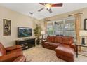 Relaxing living room featuring a large window, leather seating, entertainment center, and neutral decor at 2508 Archfeld Blvd, Kissimmee, FL 34747