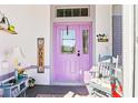 Charming front porch with decorative welcome sign and vibrant purple door at 25322 Felicity Ct, Leesburg, FL 34748