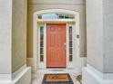 Close-up of the front door with decorative sidelights and a welcome mat at 2548 Archfeld Blvd, Kissimmee, FL 34747
