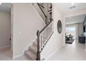 The carpeted staircase with white and wood banister leads to the upper level of the home at 2725 Serenity Garden Dr, Kissimmee, FL 34744