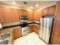 Well-lit kitchen boasts stainless steel appliances, granite countertops, and stylish cabinetry at 2822 Bella Vista Dr, Davenport, FL 33897