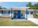 Welcoming front porch with a bright blue door, stylish planters, and charming curb appeal at 295 W Charlotte Ave, Eustis, FL 32726