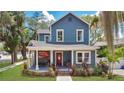 Charming two-story home with a blue facade, inviting front porch, and manicured lawn at 301 S Palmetto Ave, Sanford, FL 32771