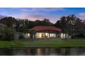 Rear view of a beautiful house overlooking a serene lake with a screened lanai and expansive backyard at 3156 Winding Pine Trl, Longwood, FL 32779