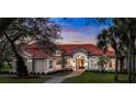 Elegant home featuring a red tile roof, arched entryway, manicured lawn, and lush landscaping, perfect for curb appeal at 3156 Winding Pine Trl, Longwood, FL 32779
