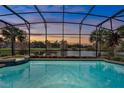 Inviting screened pool area with a spa and picturesque views of the adjacent lake and lush surroundings at sunset at 3156 Winding Pine Trl, Longwood, FL 32779