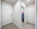 Bright hallway with neutral paint, tile flooring, and multiple doors leading to different rooms at 3764 Shoveler Ave, Leesburg, FL 34748
