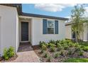 Welcoming front entrance showcasing a brick path and window with blue shutters at 3872 Giorgio Dr, Winter Haven, FL 33884