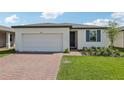 Inviting single-story home with a two-car garage, brick driveway, and lush green lawn at 3872 Giorgio Dr, Winter Haven, FL 33884