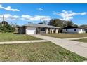 Charming single-story home with a driveway under a bright blue sky at 4207 Chateau Rd, Orlando, FL 32808