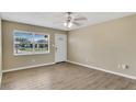 Bright, empty living room featuring wood floors, neutral walls, ceiling fan, and a window at 4207 Chateau Rd, Orlando, FL 32808