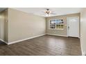 Empty living room with wood floors, neutral walls, ceiling fan, and a window at 4207 Chateau Rd, Orlando, FL 32808