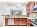 Charming kitchen offering granite countertops, stainless steel appliances, and a view of the living area at 6936 Hochad Dr, Orlando, FL 32819