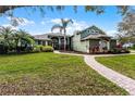 Charming home with lush green lawn, mature landscaping and brick walkway leading to the front door at 701 Palenci Ct, Winter Springs, FL 32708