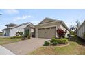 Exterior showcasing a well-kept lawn, attractive landscaping, and a paver driveway at 7977 Hanson Bay Pl, Kissimmee, FL 34747