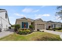 Beautiful exterior view featuring lush landscaping, a paver driveway, and a two-car garage at 7977 Hanson Bay Pl, Kissimmee, FL 34747