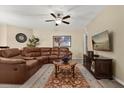 Cozy living room with leather sofa, accent rug, and entertainment center for relaxed living at 9122 Stromboli Ct, Kissimmee, FL 34747