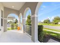 Inviting covered porch with arched entryways and white railing offering neighborhood views at 9947 Summerlake Groves St, Winter Garden, FL 34787